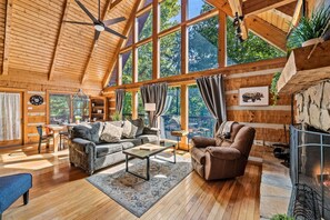 Un salón comedor amplio con techo alto, ventanas grandes y chimenea.