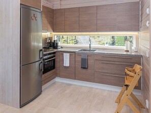 A modern kitchen with a stainless steel refrigerator, built-in oven, and a coffee maker. - Holy lake rantasauna by Interhome (Kuusamo)