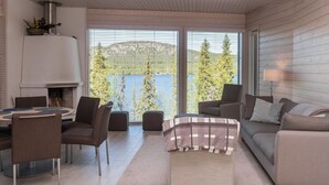 Una sala de estar moderna con chimenea, comedor y sofá.