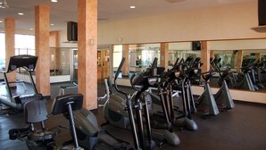 A gym with multiple treadmills and elliptical machines, large mirrors, and a ceiling fan. - FULLY BEACHFRONT CONDO WITH AMAZING OCEAN VIEWS (Puerto Peñasco)