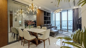 A modern living room with a dining area, large windows, and a view of the city. - Landmark 81 Serviced Residences (Ho Chi Minh City)
