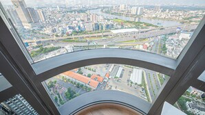 A high-rise building with a view of a cityscape, including roads, buildings, and a river. - Landmark 81 Serviced Residences (Ho Chi Minh City)