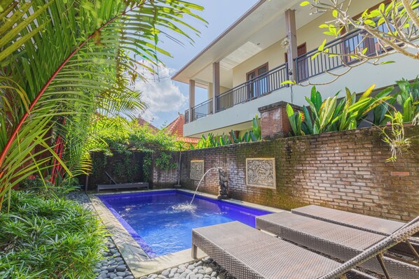 Alberca al aire libre y camastros