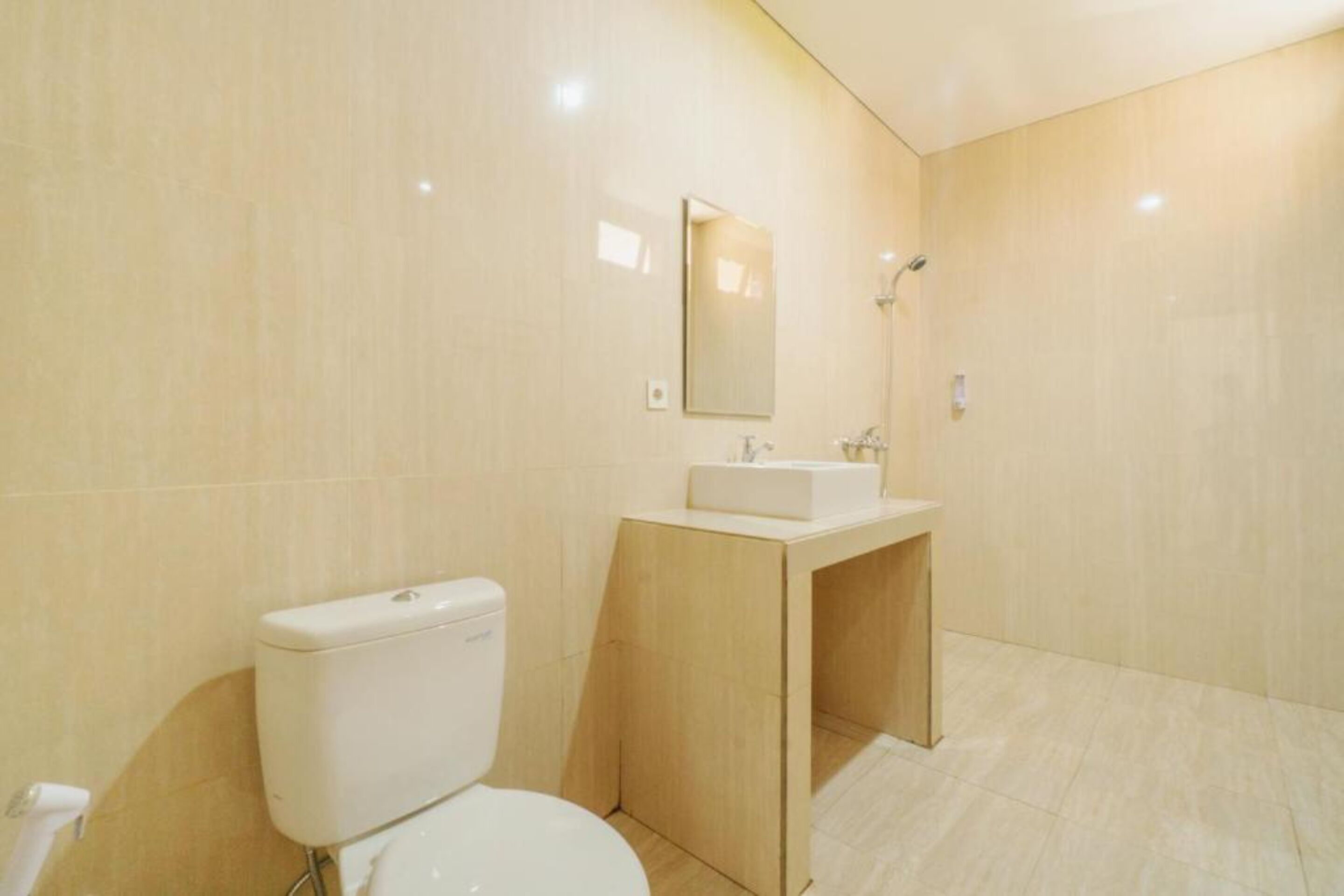 Een moderne badkamer met toilet, wastafel en spiegel.