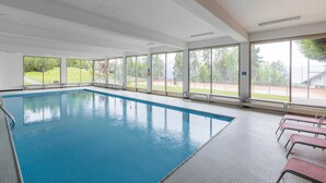 Una piscina con amplias vistas al exterior a través de grandes ventanales.
