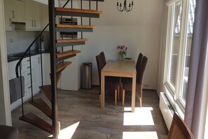 A modern kitchen with white cabinets, a stainless steel sink, and a wooden staircase. - Holiday Home Tuitjenhorn near Coast (Tuitjenhorn)