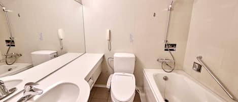 A modern bathroom with a large mirror, two sinks, a toilet, and a bathtub.