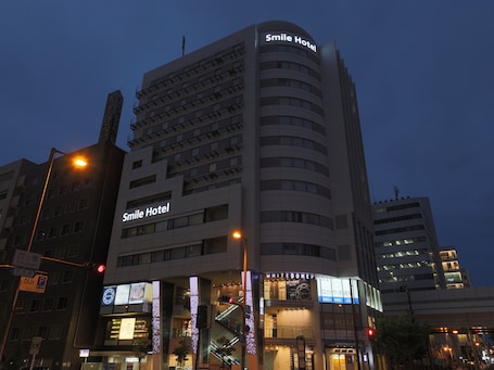 A multi-story building with the sign "Smile Hotel" on the facade.