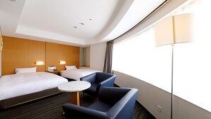 Een hotelkamer met twee bedden, een tafeltje en een stoel.