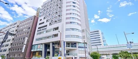 A multi-story hotel with a modern design, featuring a prominent signage for the Smile Hotel.