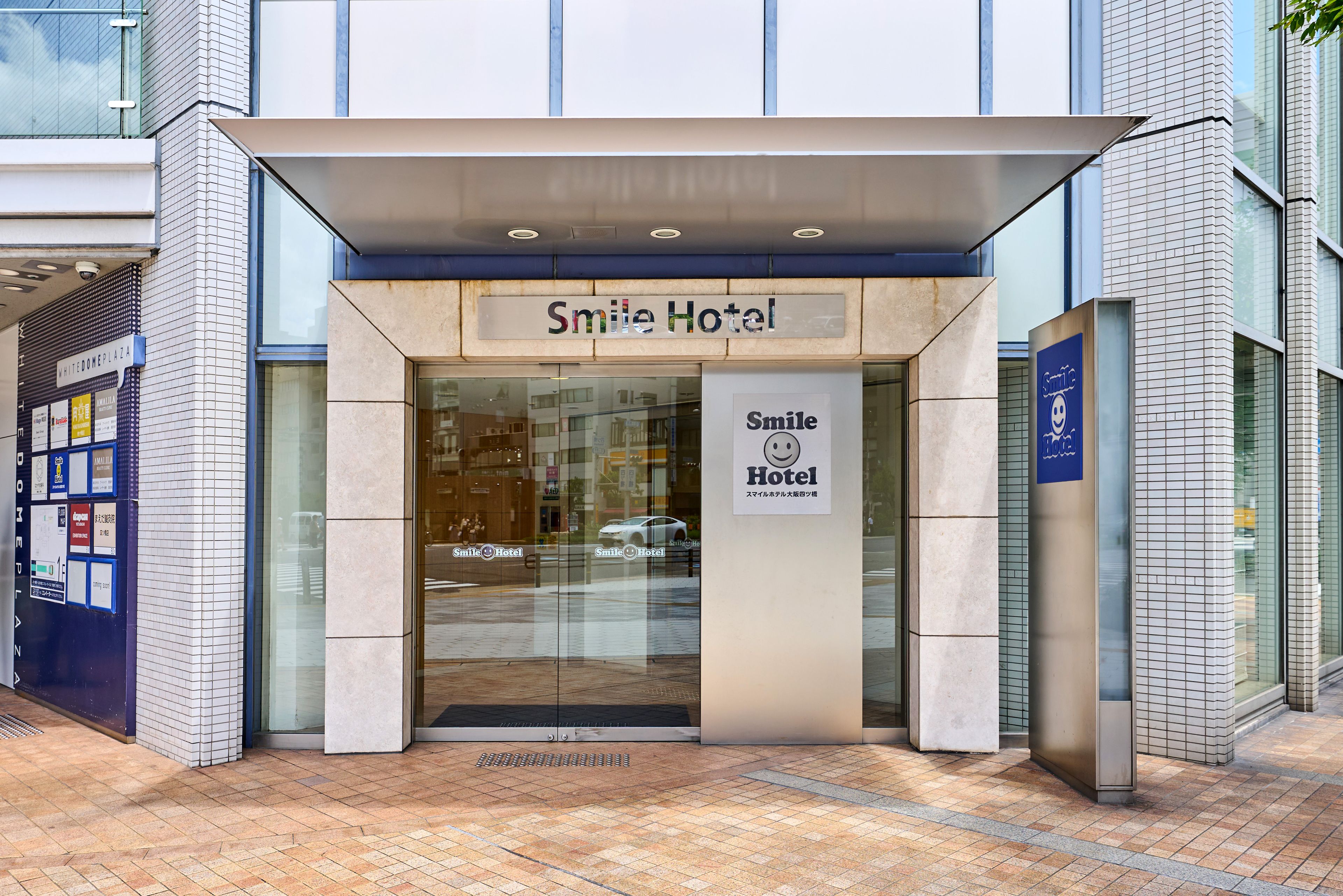 L’entrée d’un hôtel, avec une enseigne indiquant « Smile Hotel ».