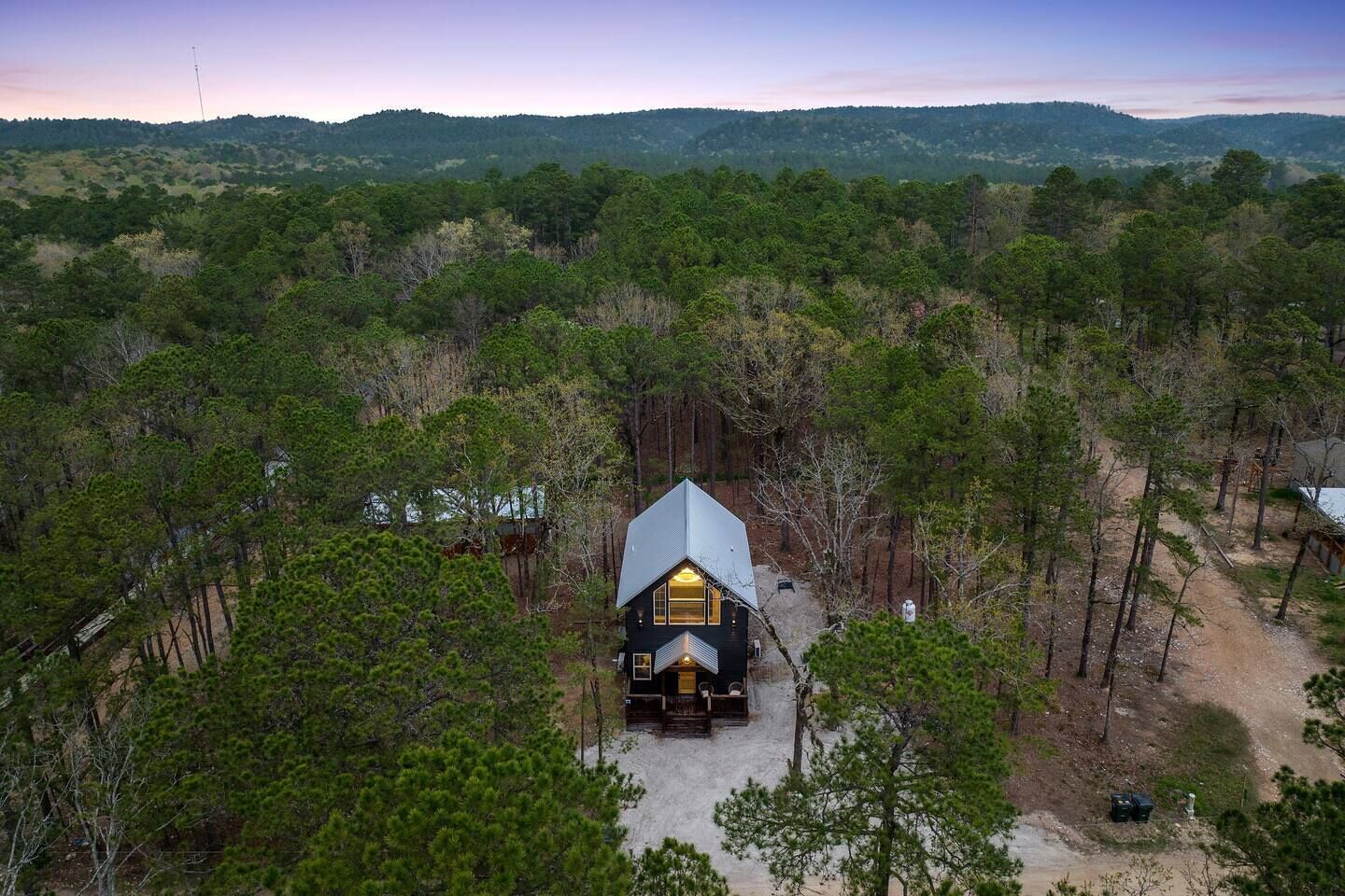 Una cabaña rodeada de un bosque denso con vistas despejadas del paisaje circundante.