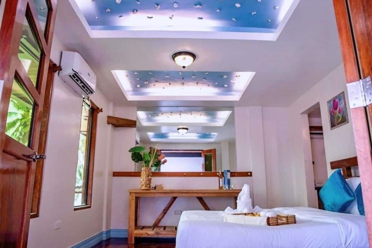 Une chambre d’hôtel équipée d’un lit, d’un bureau, d’un plafond doté de lucarnes et d’un appareil de climatisation.