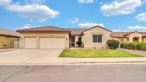 A residential house with a garage, a front lawn, and a clear sky. - Spacious 4 bed, Sparkling Pool, Game Room, Pool Table, Arcade, Sleeps 19 (Mesa)