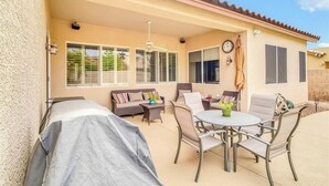A covered patio with a dining table and chairs, a barbecue grill, and a sofa with cushions. - Spacious 4 bed, Sparkling Pool, Game Room, Pool Table, Arcade, Sleeps 19 (Mesa)