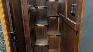 A narrow, wooden interior with a series of steps leading to a higher level. - Lavender Limited at Olympic Railway Inn - Pet Friendly (Sequim)