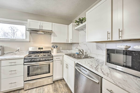 Prepare meals in the fully equipped kitchen with a stainless steel range, cabinetry, and dishwasher.