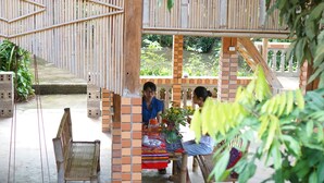 An outdoor seating area with brick pillars and a wooden pergola.