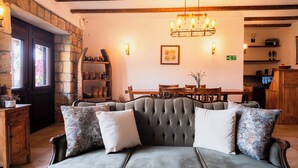 A cozy living room with a tufted sofa, wooden furniture, and a chandelier. - Arıklı Han Kazdağları (Ayvacik)