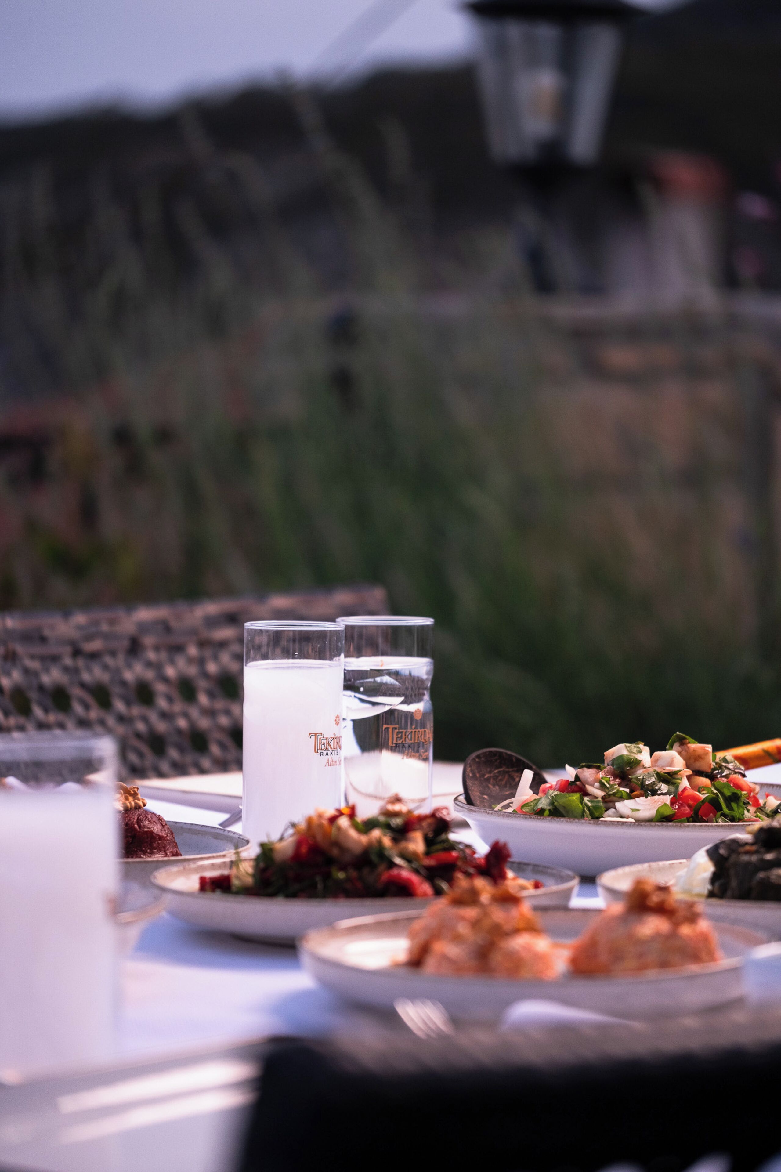 Una mesa servida con diferentes platos y vasos, presumiblemente para una comida.