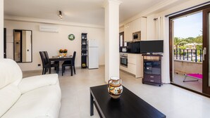 A modern apartment with a dining area, kitchen, and a balcony with a view.