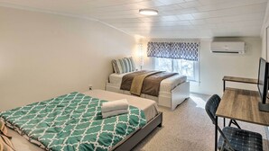 Un dormitorio con cama, escritorio y silla.