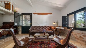 Una sala de estar acogedora con un sofá de cuero, una mesa de centro de madera y un tapete estampado.