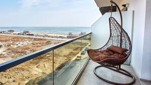Ein Balkon mit einer Hängematte und Blick auf Strand und Meer.