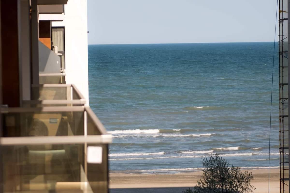 Un balcon avec vue sur la mer et une plage.