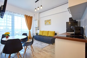 Ein modernes Wohnzimmer mit Essbereich, Sofa und Küche.