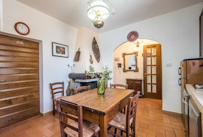 A dining area with a wooden table and chairs, a clock, and a decorative mirror.