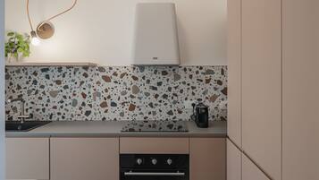 Una cocina moderna con una encimera, cafetera y horno empotrado.