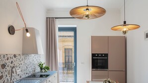 Een moderne keuken met een ingebouwde kookplaat, een spoelbak en een eethoek met een tafel en stoelen.