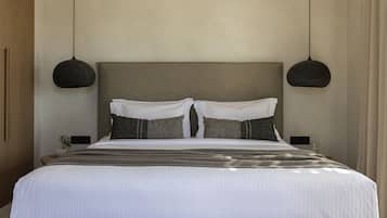 Un dormitorio moderno con una cama grande, dos mesitas de noche y lámparas colgantes.