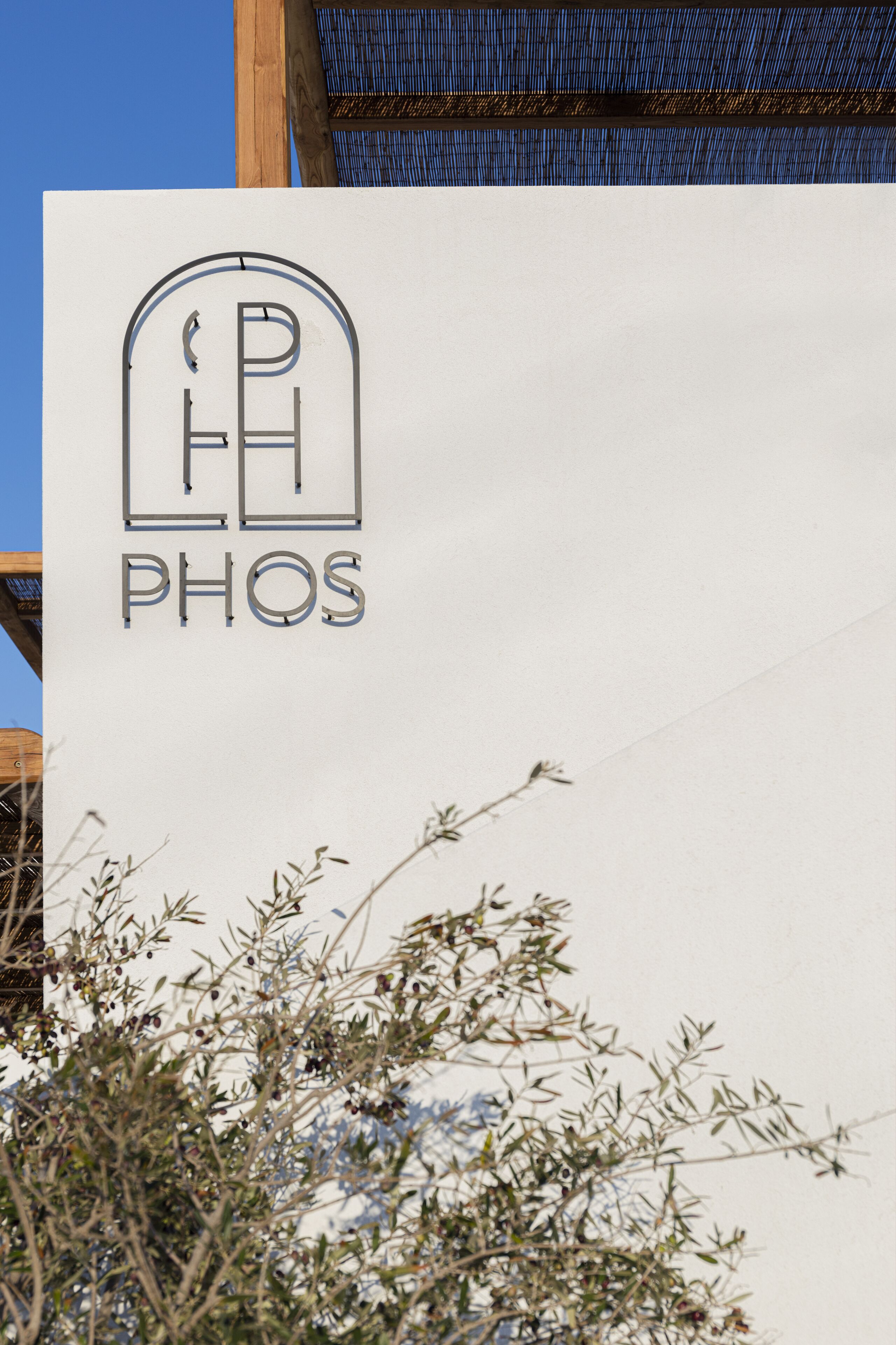 Un edificio con un cartel que dice 'PHOS' en una tipografía estilizada.