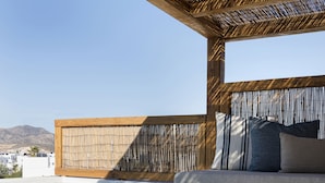 Ein moderner Außenbereich mit Sitzgelegenheiten, einem Pool, einer Holz-Pergola und Blick auf die Berge.