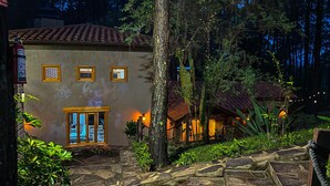 Un edificio de piedra con techo de tejas, puerta de madera y una ventana pequeña.