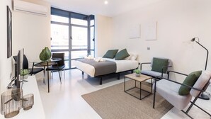 A modern, well-lit room with a bed, seating area, and a desk. - La Latina studio in the heart of Madrid (Madrid)