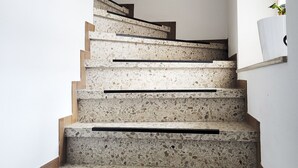 A staircase with terrazzo steps and wooden handrails, leading to a landing. - Vacation apartment between the North Sea and the Baltic Sea - Fitness room (Ostenfeld)