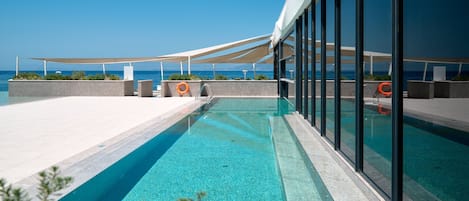 Una piscina techada, una piscina al aire libre de temporada, sombrillas