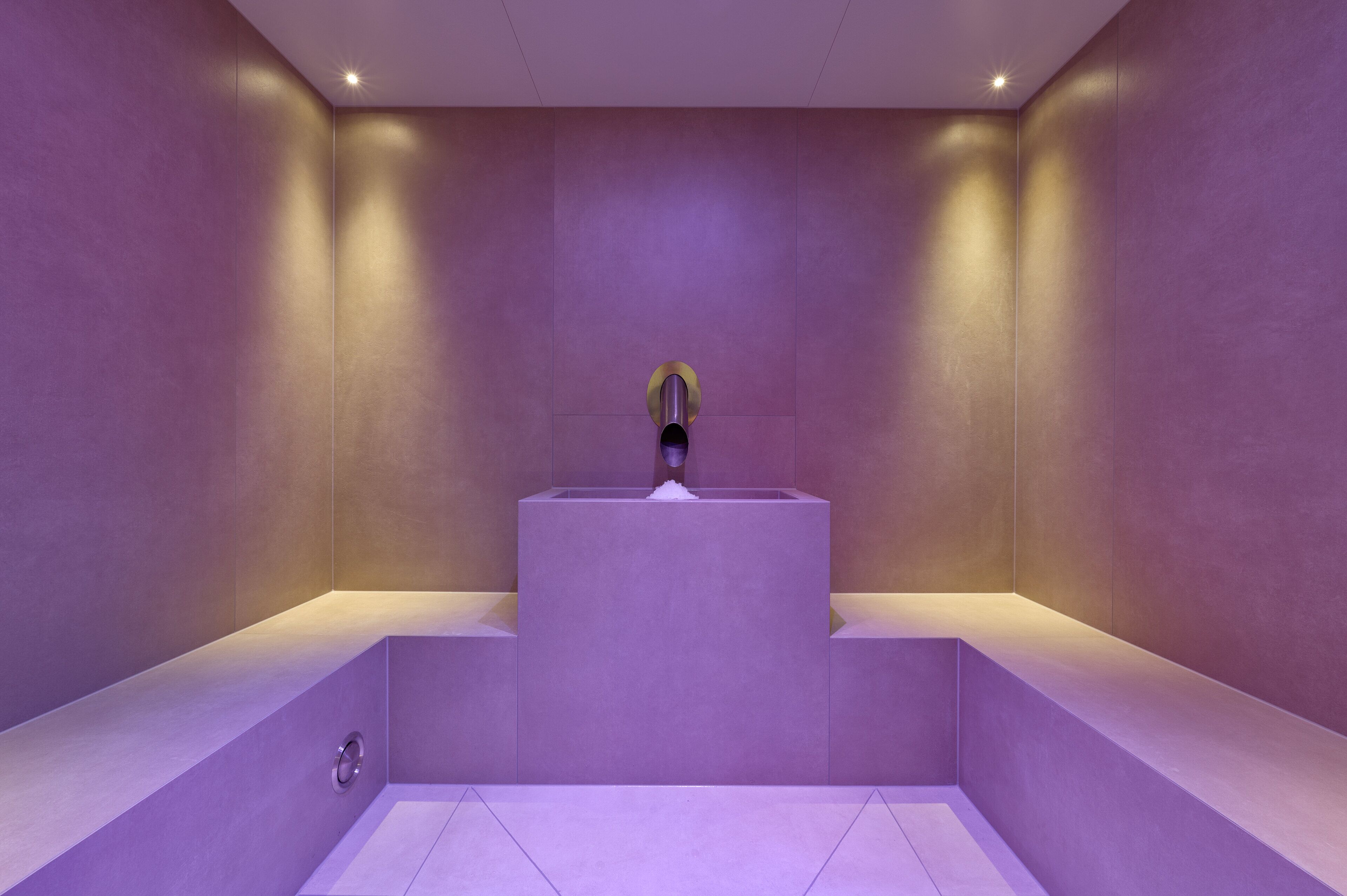 Un baño moderno con un lavamanos central y un espejo grande.