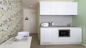 Eine kleine Küche mit Mikrowelle, Toaster und Wasserkocher auf der Arbeitsplatte.
