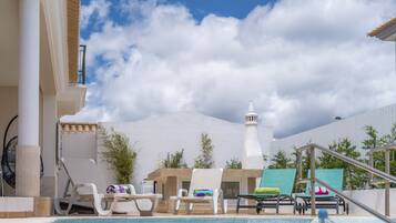 Una piscina al aire libre, una piscina climatizada, sombrillas