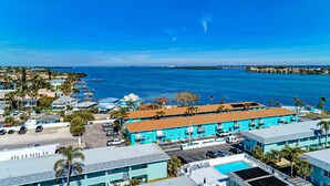 Ein Küstenhotel mit mehreren Gebäuden, einem Parkplatz und Blick aufs Meer.
