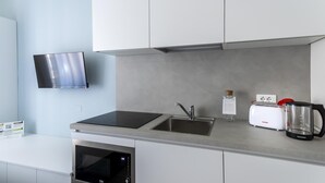 Eine moderne Küche mit Einbau-Mikrowelle, einem Herd, einer Spüle und einem Toaster.