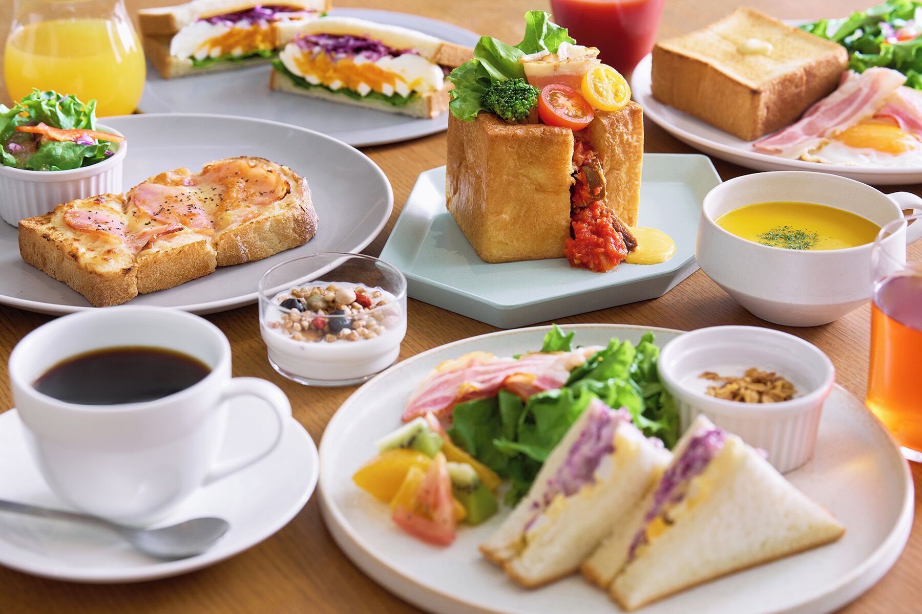 Variedad de opciones para el desayuno, incluyendo sándwiches, un tazón de sopa y una taza de café.