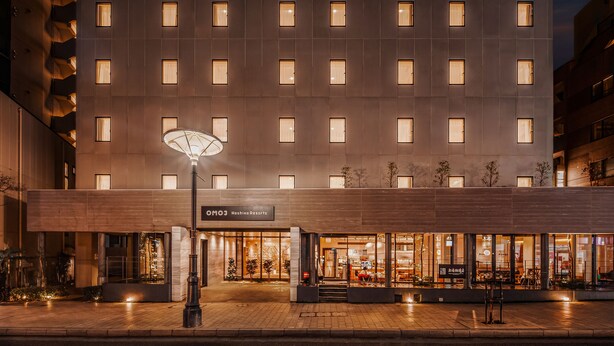 A modern hotel with a symmetrical facade, multiple windows, and a well-lit entrance. - OMO3 Tokyo Akasaka by Hoshino Resorts (Tokyo)