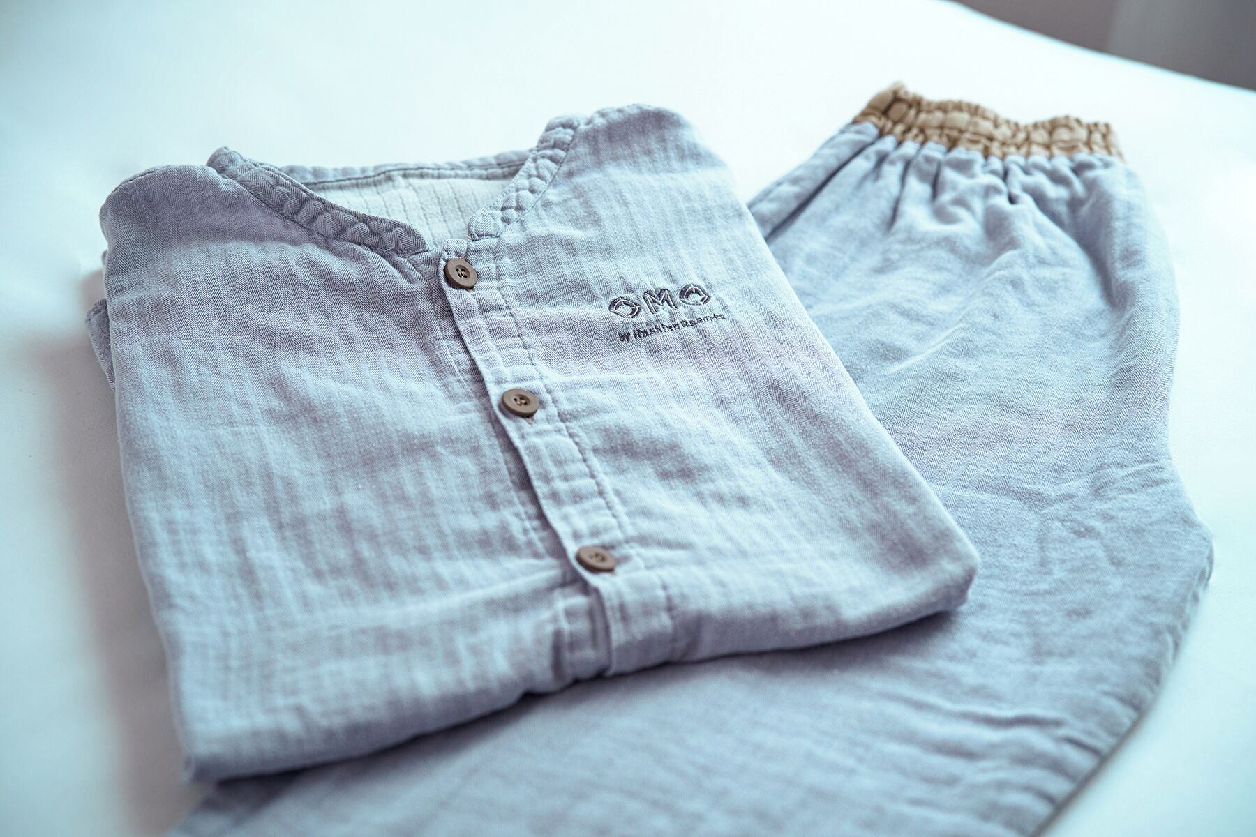 A neatly folded piece of clothing with a button and a tag.