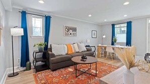 A modern living room with a sofa, coffee table, and dining area.