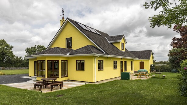 A yellow house with a patio and picnic table. - Large Country House, Sleeps 10, Family Friendly (Westport)